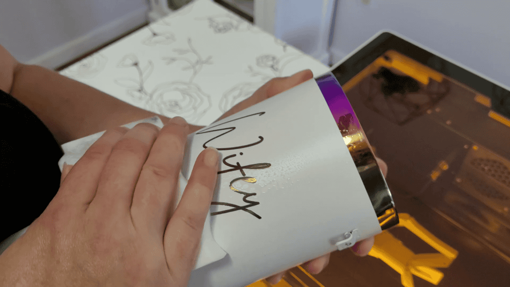 Hands lifting the finished Wifey engraved tumbler out of the WeCreat Vista