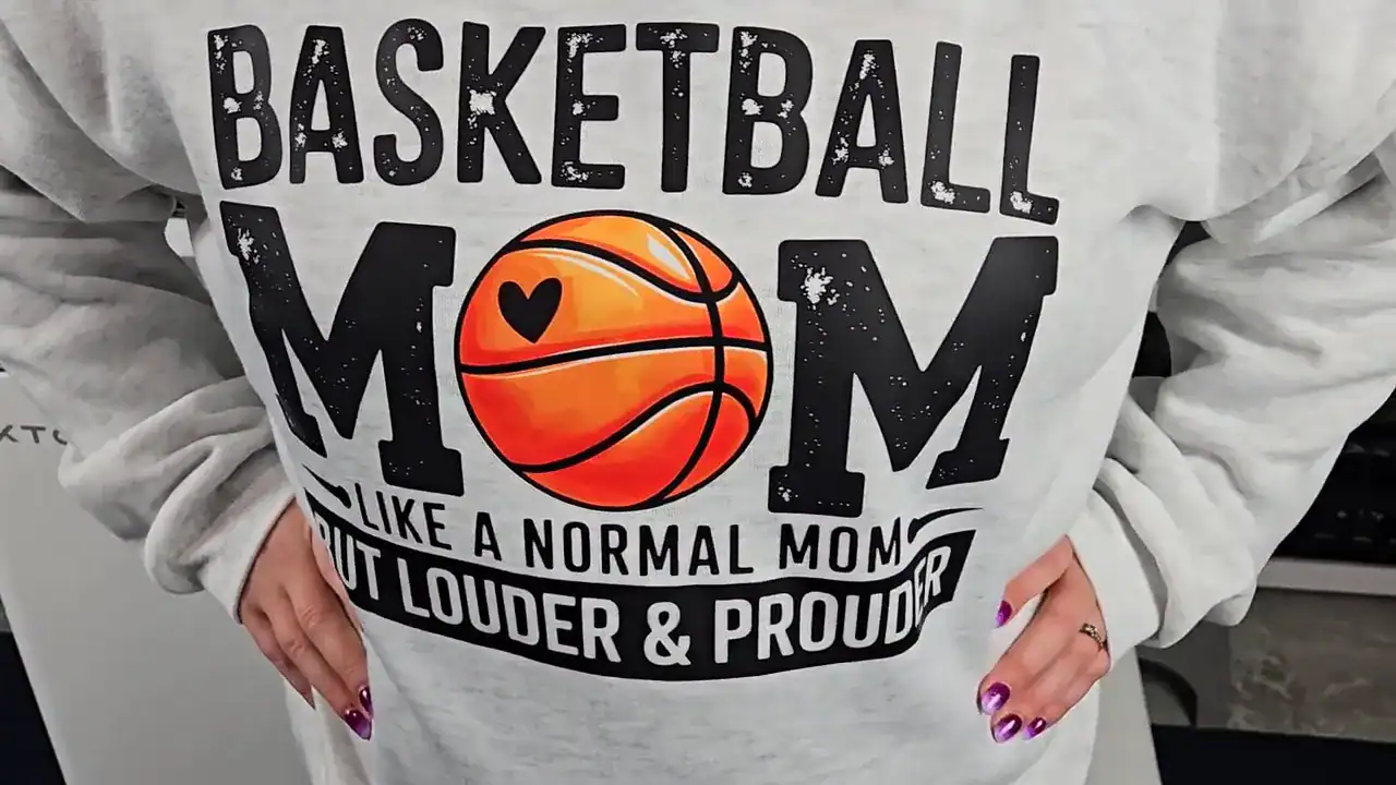 lose-up of a gray Basketball Mom sweatshirt with an orange basketball heart design, DTF printed using the xTool Apparel Printer.