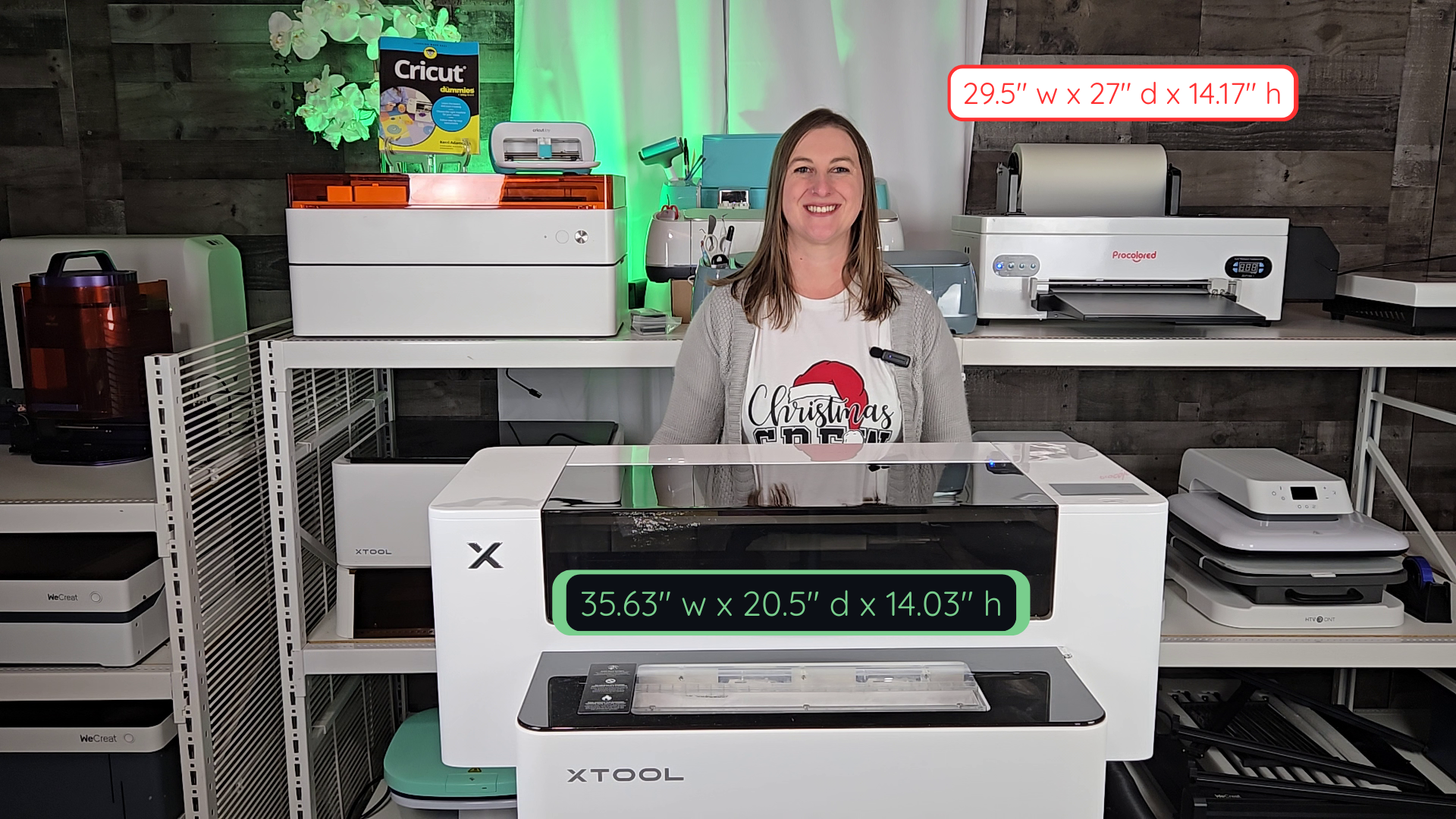 Craft room overview showing Kerri Adamczyk with xTool Apparel Printer dimensions labeled (35.63" w x 20.5" d x 14.03" h) and Procolored F13 dimensions (29.5" w x 27" d x 14.17" h) for size comparison