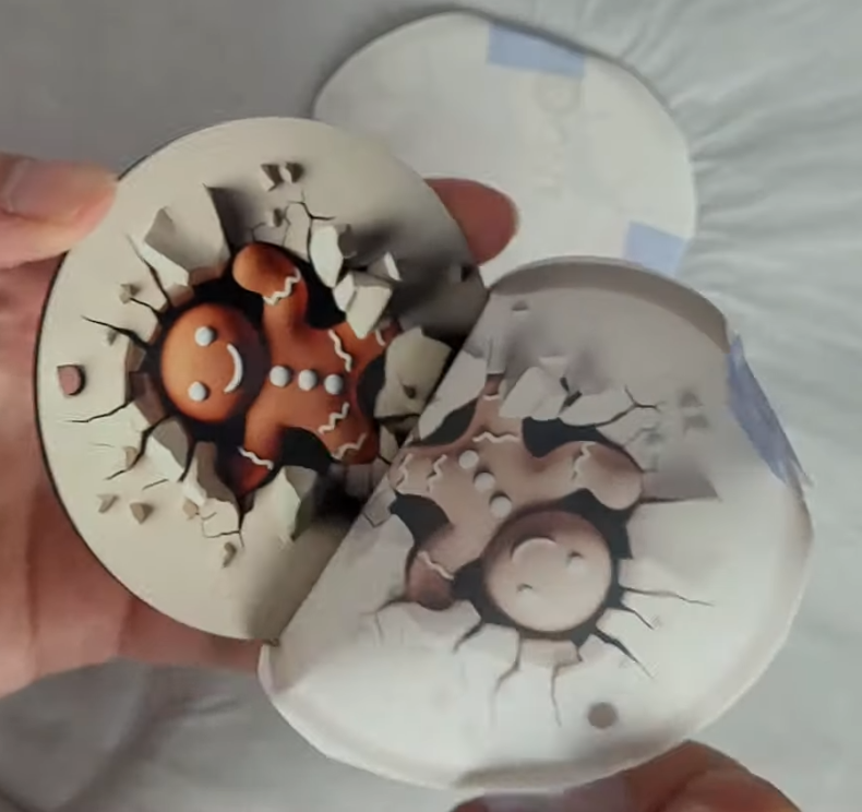 How to Make 3D Sublimation Ornaments That Pop Right Off the Surface 13 Holding finished sublimation ornaments showing the funny 3D gingerbread man design - front shows smiling face breaking through, back shows the gingerbread booty with matching cracked surface effect