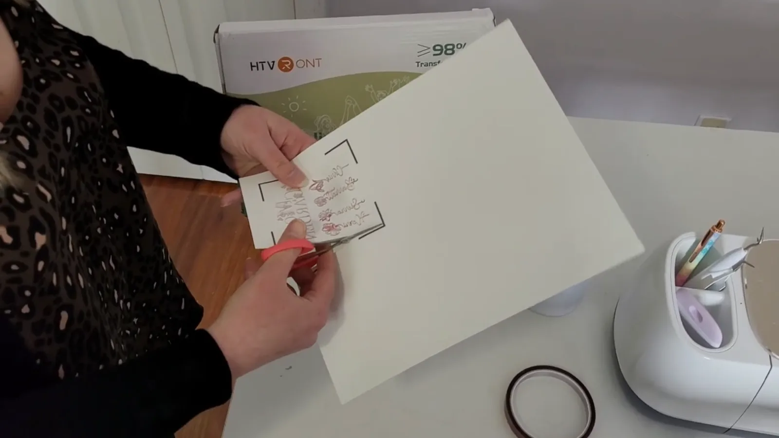 Cutting a printed sublimation mug design out of the sheet with scissors