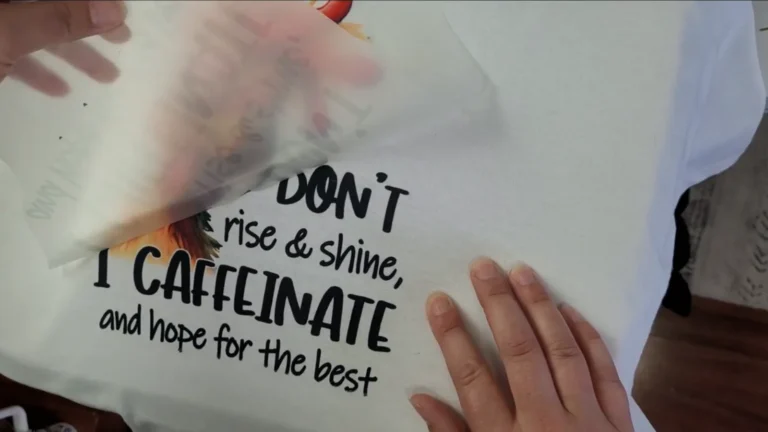 Peeling the DTF transfer film off a white cotton shirt after pressing