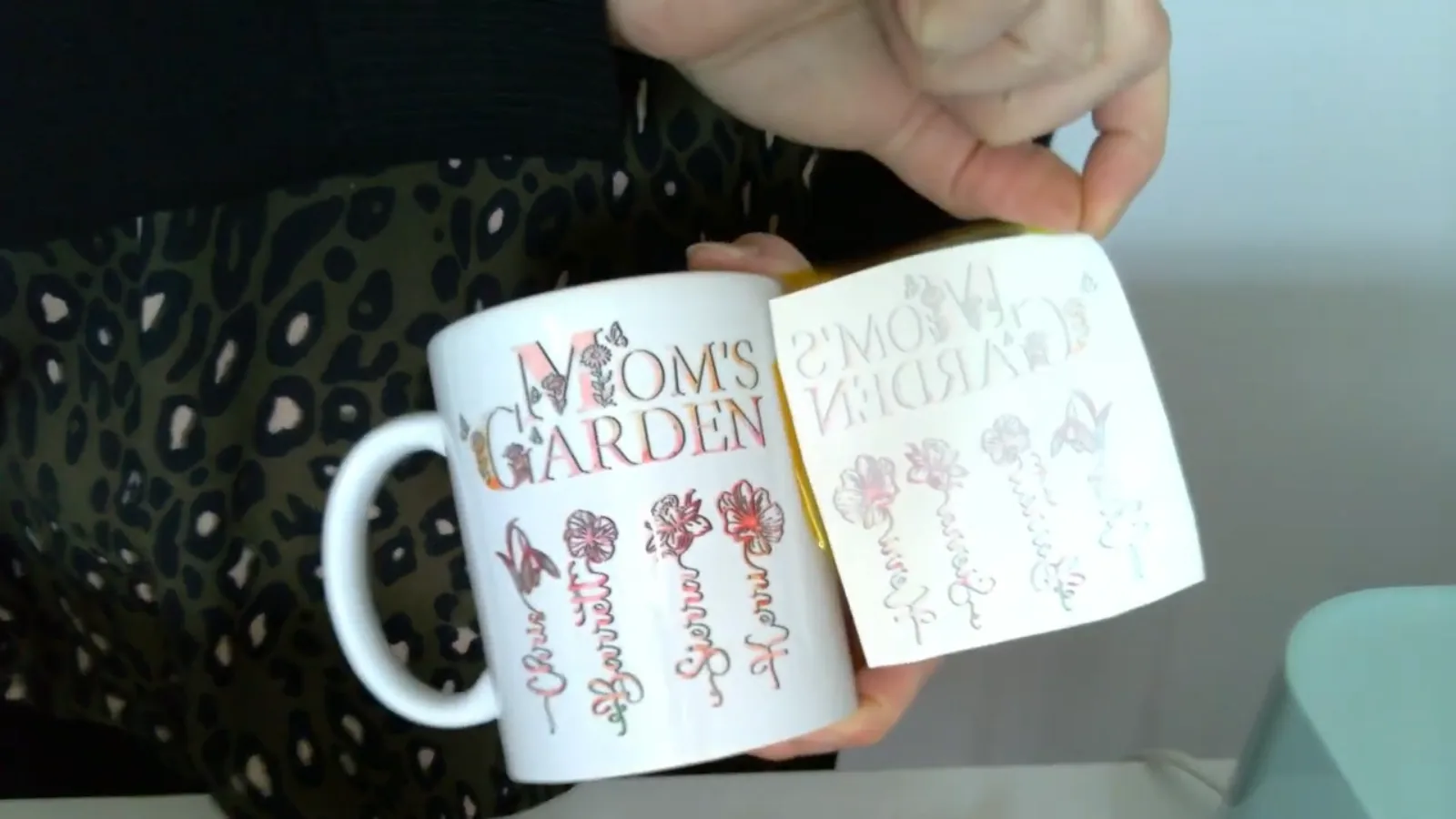 Peeling the spent sublimation paper away from a finished mug to reveal the colour