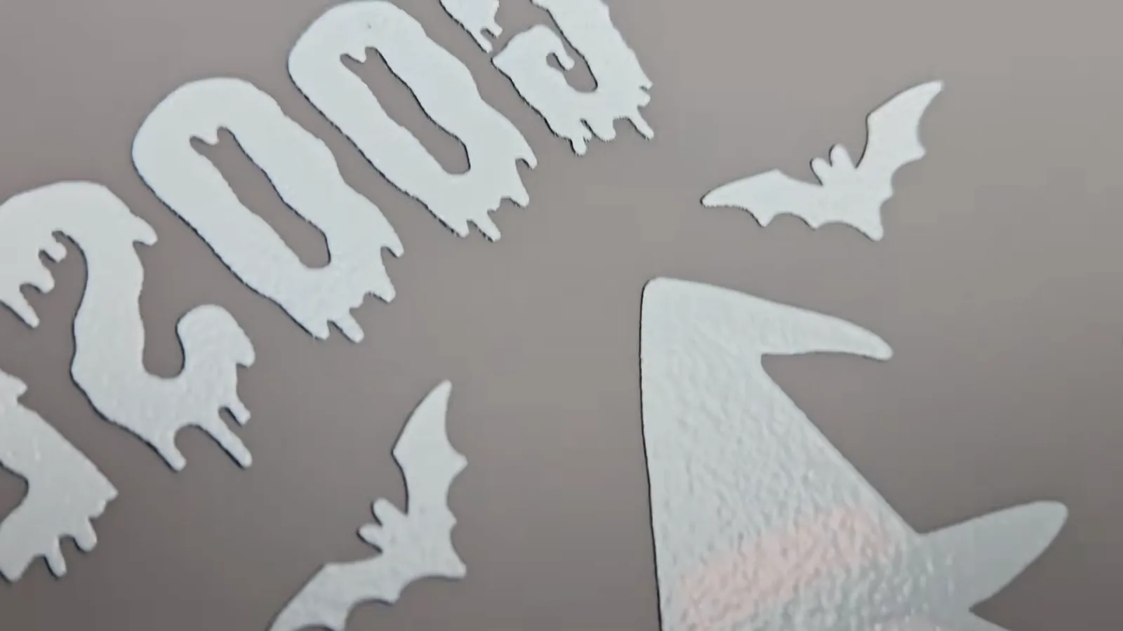 Close up of a cured DTF transfer showing the textured white ink underbase behind a mirrored Halloween design