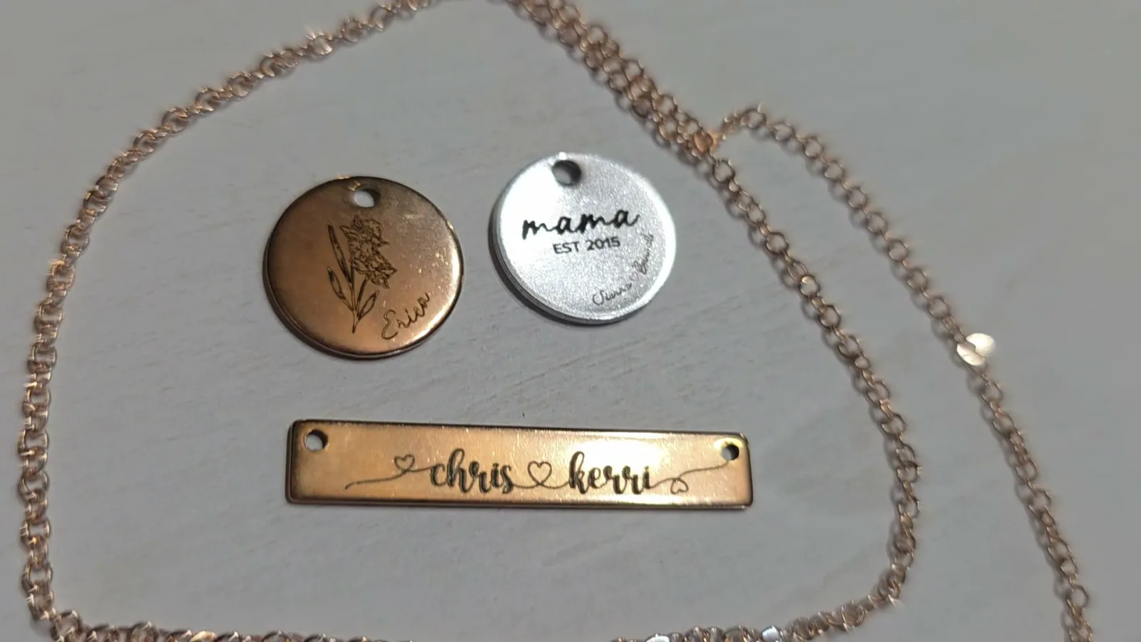 Personalized silver and rose gold jewelry pendants and a bar necklace engraved with names using the MOPA fiber laser