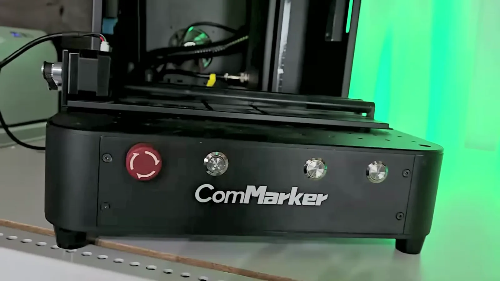 Releasing the red E-stop button to power on the ComMarker Omni X UV laser