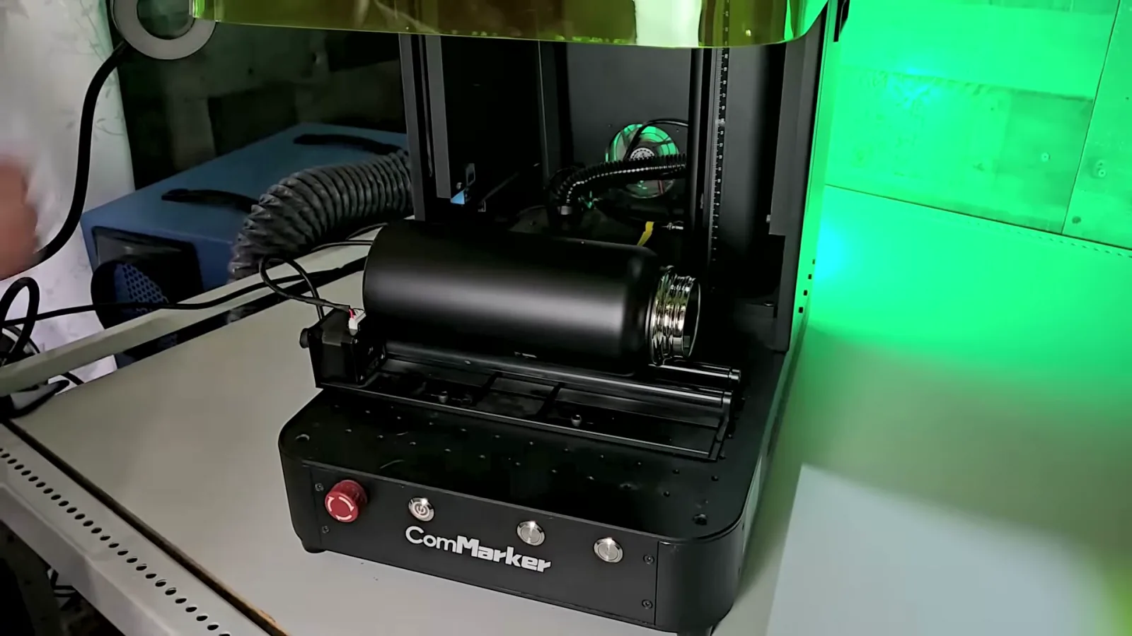 ComMarker Omni X UV laser with the R5 rotary roller and a black tumbler loaded for batch engraving
