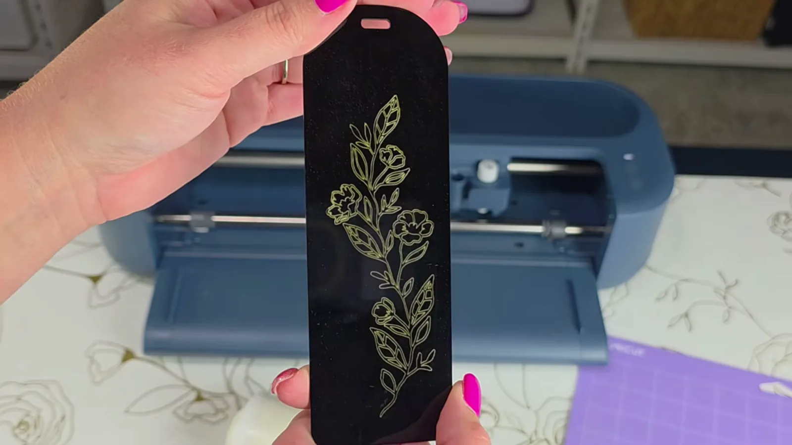 Black acrylic bookmark engraved with a floral design on a Cricut Maker 5 and filled with gold paint marker