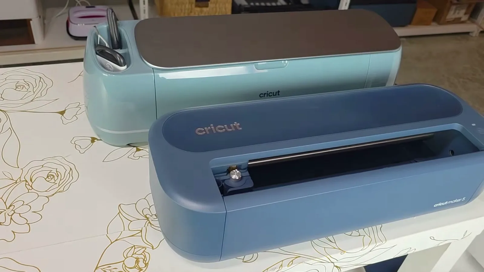 Slate blue Cricut Maker 5 in front of a sage Cricut Maker 4 showing the smaller, lower design with no lid