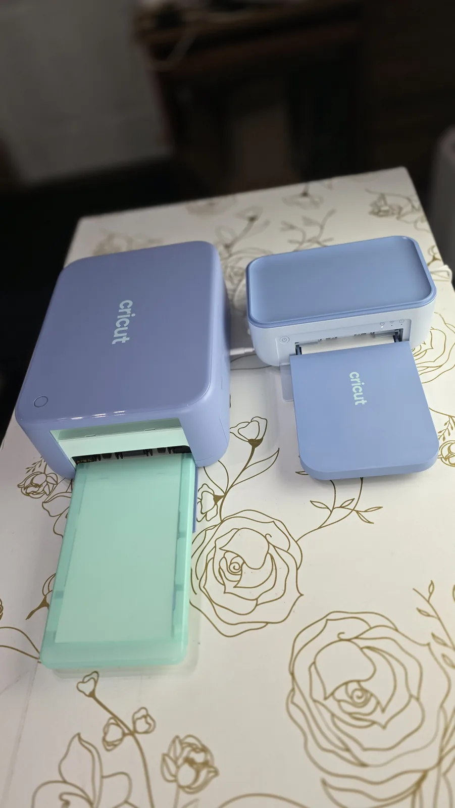 Cricut StickerPix Print + Cut with its mint paper tray pulled out next to the smaller StickerPix Print