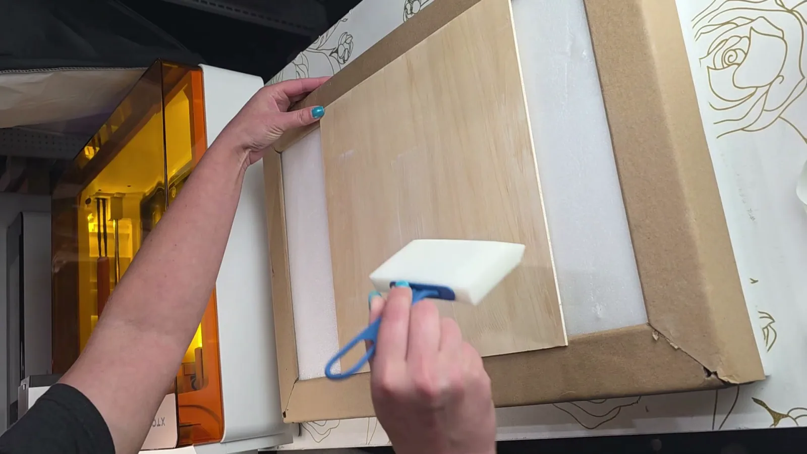 Brushing white inkAID coating onto a sheet of basswood with a foam brush before printing on it